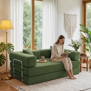 Peut inclure: Un canap&eacute; modulaire vert en velours c&ocirc;tel&eacute;. Le canap&eacute; a une conception empil&eacute;e avec des accoudoirs et des dossiers. Une personne est assise sur le canap&eacute; en train de lire un livre. Un lampadaire dor&eacute; et une tenture murale en macram&eacute; sont &eacute;galement visibles.