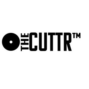 May include: A black graphic logo on a white background featuring a solid black circle with a small white dot in the center, followed by the text THE CUTTR in a bold, sans-serif font, with a trademark symbol positioned to the right of the text.