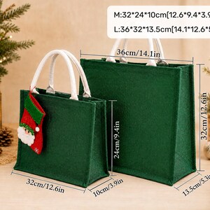K&ouml;nnte beinhalten: Zwei dunkelgr&uuml;ne Filztaschen mit wei&szlig;en Henkeln. Die kleinere Tasche ist mit einem Weihnachtsmann-Strumpf verziert. Die Ma&szlig;e betragen M: 32 x 24 x 10 cm und L: 36 x 32 x 13,5 cm. Die Taschen haben einen rechteckigen Boden und eine feste Form.