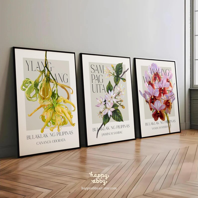 Może przedstawiać: Trzy oprawione botaniczne wydruki artystyczne z akwarelowymi ilustracjami kwiat&oacute;w. Wydruki wyświetlają teksty "Ylang-Ylang", "Sampaguita" i "Waling-Waling" z ich nazwami naukowymi oraz tekstem "Bulaklak ng Pilipinas". Wydruki są eksponowane na drewnianej podłodze.