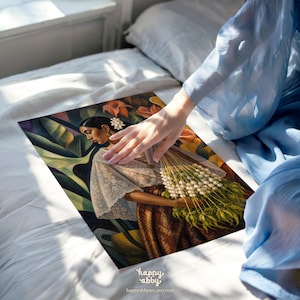 May include: A rectangular art print featuring a painting of a person in a white lace blouse and brown patterned skirt, holding a large bouquet of white flowers against a backdrop of dark green tropical leaves and orange floral elements.