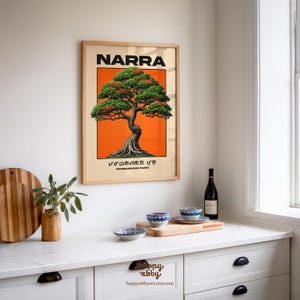 Puede incluir: Una l&aacute;mina de arte enmarcada que presenta una ilustraci&oacute;n estilizada de un &aacute;rbol Narra centrado sobre un fondo rectangular de color naranja vibrante. La palabra NARRA est&aacute; impresa en letras negras negritas en la parte superior, con escritura Baybayin y el texto PAMBANSANG PUNO debajo.
