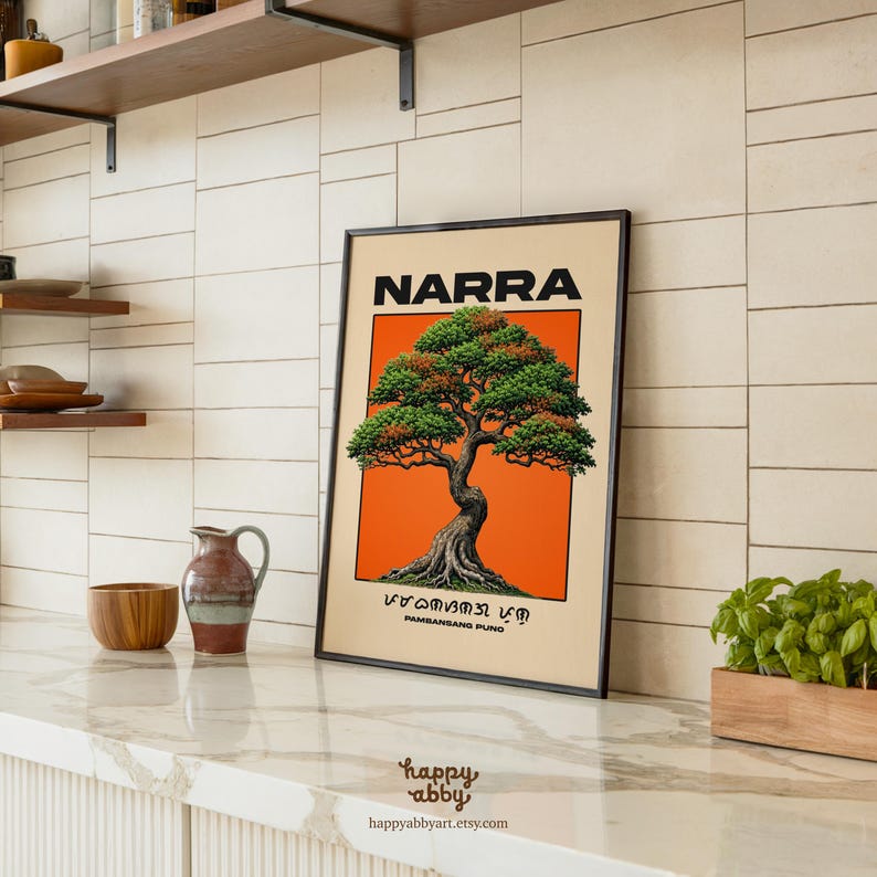 Puede incluir: Una l&aacute;mina art&iacute;stica rectangular enmarcada que presenta una ilustraci&oacute;n detallada de un &aacute;rbol Narra centrado sobre un fondo naranja vibrante. El texto NARRA aparece en la parte superior, con escritura Baybayin y las palabras PAMBANSANG PUNO debajo.