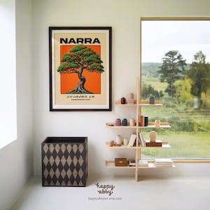 Puede incluir: Una l&aacute;mina enmarcada con una ilustraci&oacute;n estilizada de un &aacute;rbol Narra sobre un fondo naranja vibrante, con el texto "NARRA" y "PAMBANSANG PUNO" en negro, situada sobre un contenedor de madera oscura con patr&oacute;n de rombos y una estanter&iacute;a.