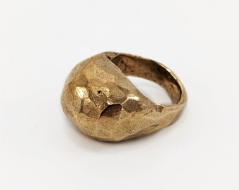Gebeeldhouwde koepelvormige lichtbronzen ring.