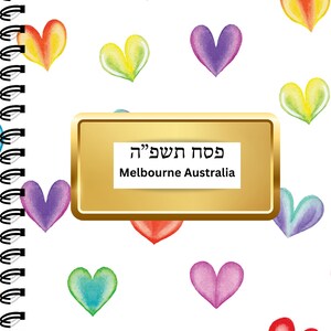 May include: A white notebook with a gold label that says "פסח שמח" and "Melbourne Australia". The notebook has a spiral binding and is decorated with colorful watercolor hearts.