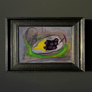 May include: An abstract painting in a dark, ornate frame. The artwork depicts a still life with a yellow fruit, dark berries, and a glass. The painting has a muted color palette with green, yellow, and brown tones.