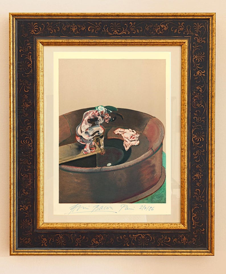 May include: Framed print of a Francis Bacon painting. The artwork depicts a figure in a circular structure with a dark brown frame and gold accents. The print has a beige background and a signature at the bottom.