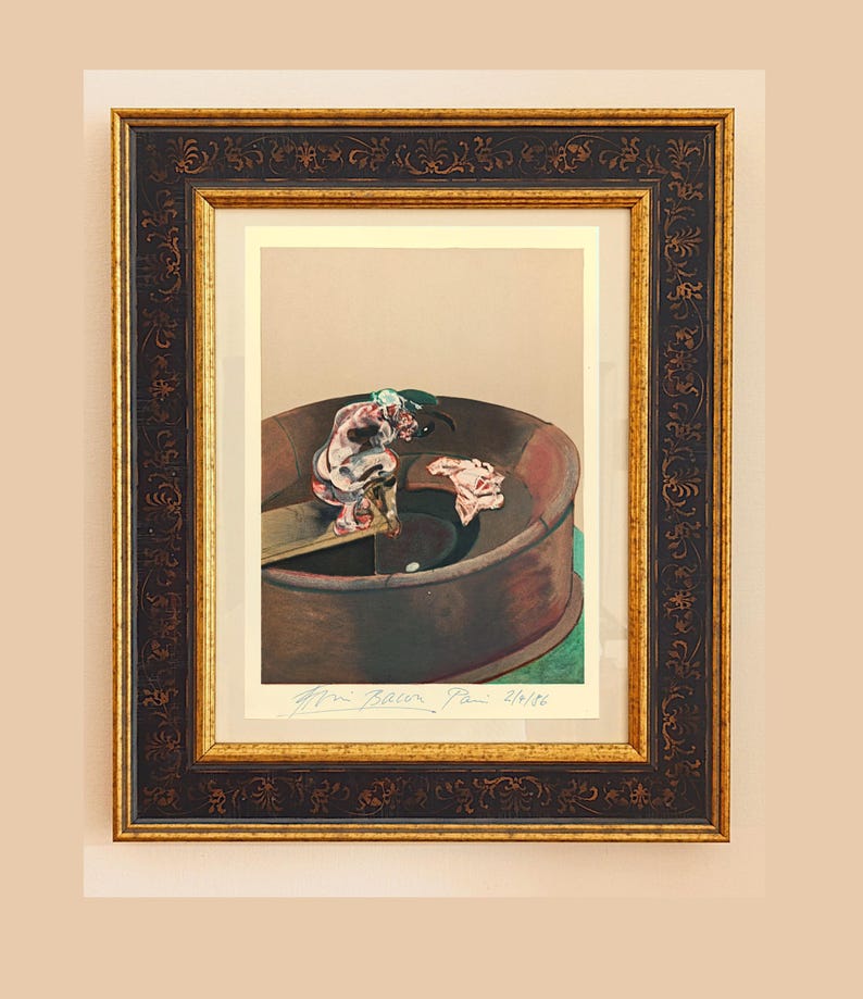May include: Framed artwork featuring a painting of a figure in a circular structure. The artwork is in a dark brown frame with gold accents. The painting has a muted color palette with a signature and edition number visible.