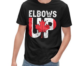 May include: Black t-shirt with a white graphic that says "Elbows Up" with a Canadian flag design featuring a red maple leaf.