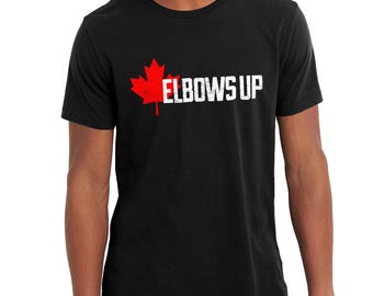 May include: Black t-shirt with a red Canadian maple leaf and the text "Elbows Up" in white.