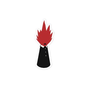 Puede incluir: Una pegatina con una ilustración estilizada de una figura. La figura tiene una cabeza roja en forma de llama y un solo ojo. Lleva un abrigo negro con cuello blanco y tres pequeños botones. El diseño es simple y gráfico.