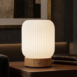 May include: A cylindrical table lamp with a white, vertically ribbed, translucent shade and a light-toned wooden base featuring a small circular power button. The text www.nameandcharm.etsy.com is displayed at the bottom of the image.