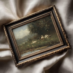May include: A rectangular framed painting featuring a landscape scene with several white ducks and ducklings near a body of water and trees. The frame is black with ornate gold-colored detailing along the inner and outer edges of the border.