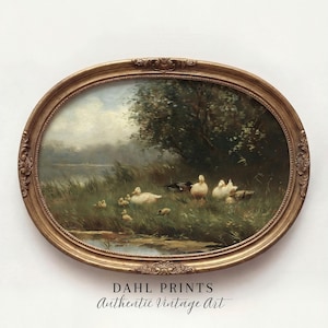 May include: An oval-shaped, ornate gold frame containing a landscape painting of a group of white ducks and ducklings in a grassy field near a pond. The text DAHL PRINTS Authentic Vintage Art is printed in black below the framed artwork.