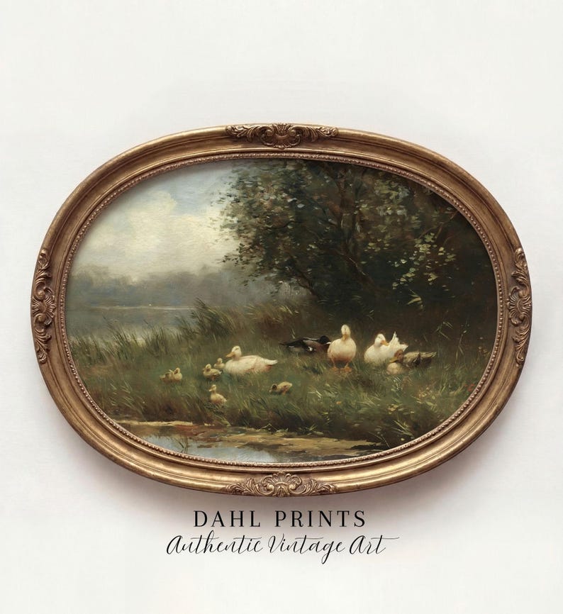 May include: An oval-shaped, ornate gold frame containing a landscape painting of a group of white ducks and ducklings in a grassy field near a pond. The text DAHL PRINTS Authentic Vintage Art is printed in black below the framed artwork.