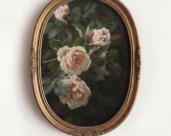 May include: An oval-shaped, ornate gold frame containing a painting of pale pink roses with dark green leaves against a deep, dark background. The text DAHL PRINTS is printed in dark blue capital letters centered below the framed artwork.