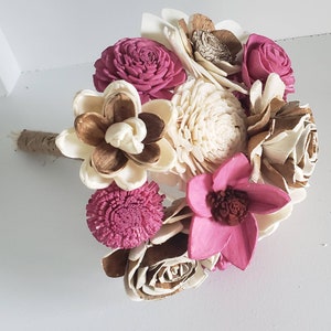 Könnte beinhalten: Ein Strauß aus Sola-Holzblumen in Rosa- und Cremetönen. Der Strauß enthält verschiedene Blumenformen und -größen, darunter Rosen, Pfingstrosen und Lilien.