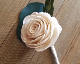 May include: A white sola wood flower boutonniere with a single rose and green foliage.