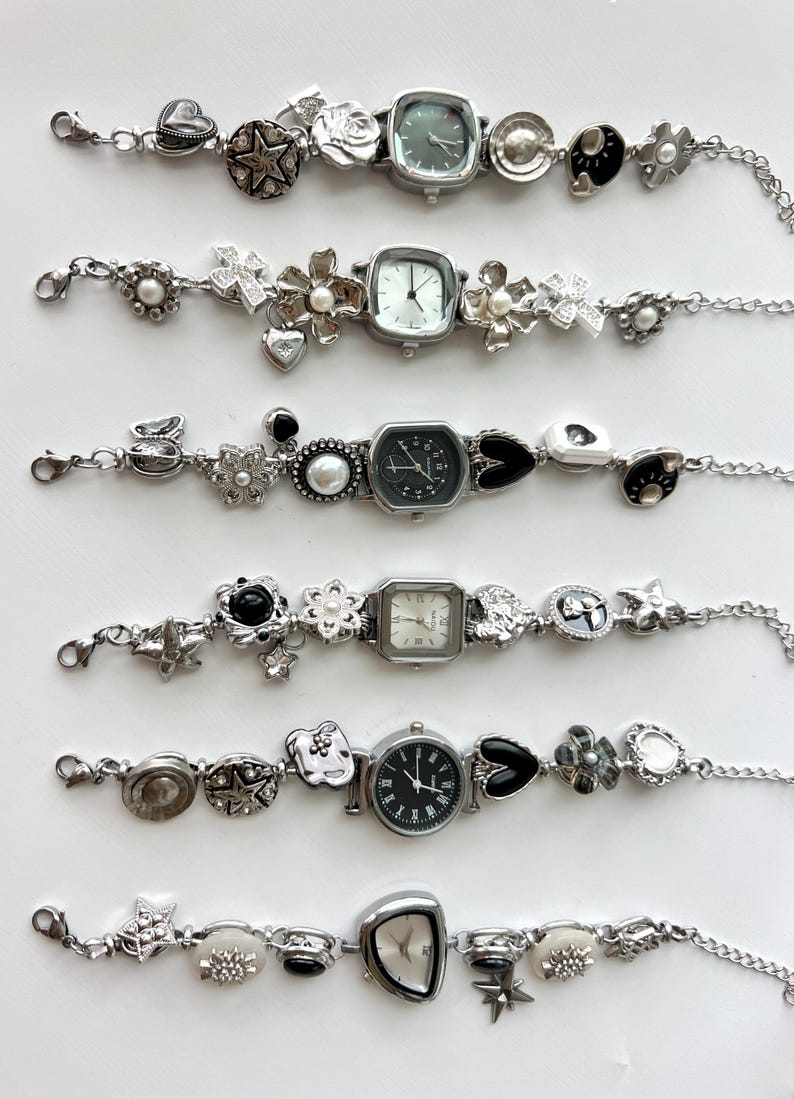 May include: Six silver charm bracelets with watch faces. Each bracelet has a different watch face shape, surrounded by decorative charms such as hearts, stars, flowers, and pearls. The watch faces have black or white dials.