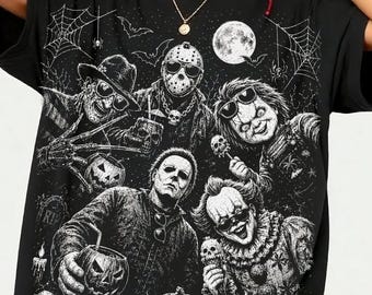Może przedstawiać: Czarny t-shirt z białym nadrukiem graficznym przedstawiającym różne postacie z horrorów, w tym postać w masce hokejowej, postać z pazurami, lalkę i klauna, w otoczeniu dyń, pajęczyn, nietoperzy i pełni księżyca.