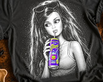 Może przedstawiać: Czarny t-shirt z białą ilustracją kropkowaną przedstawiającą osobę z długimi włosami i okularami przeciwsłonecznymi na głowie, noszącą naszyjnik z krzyżykiem i trzymającą fioletową puszkę napoju energetycznego Alani Witch's Brew.