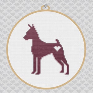 May include: Embroidered cross-stitch design of a brown dog with a heart on its back, framed in a round wooden hoop.
