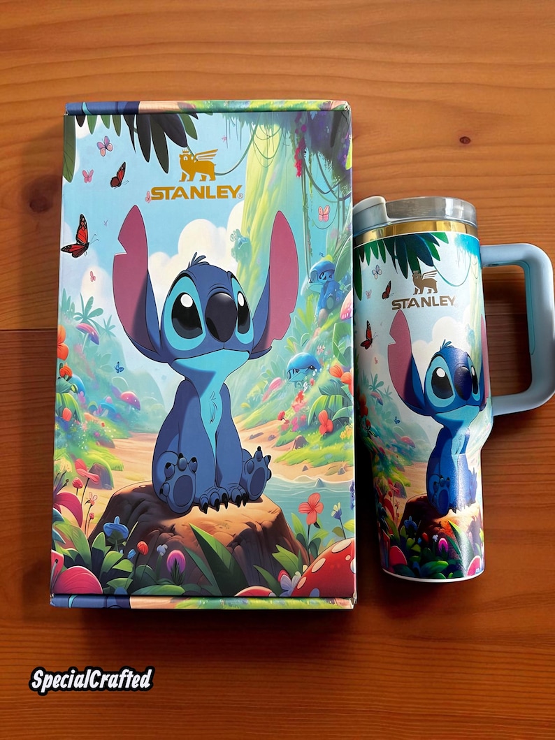 May include: A Stanley travel mug and box set featuring the character Stitch from Lilo & Stitch. The mug and box have a colorful design with Stitch sitting on a rock in a tropical setting. The box has the text "SpecialCrafted".