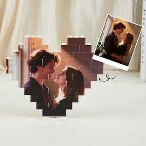 May include: A heart-shaped photo display made of brown blocks, featuring a couple's photo. A smaller photo is attached. The base has the initials "M J". A romantic gift idea.