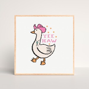 May include: Cross stitch pattern featuring a cartoon goose wearing a pink cowboy hat and a turquoise necklace. The goose is walking and the text "YEE HAW" is above it.