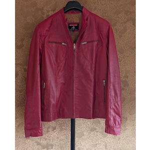 Puede incluir: Una chaqueta de cuero roja con cierre de cremallera y varios bolsillos. La chaqueta tiene un cuello de pie y un logotipo "Riding Horse" en el lado izquierdo del pecho.