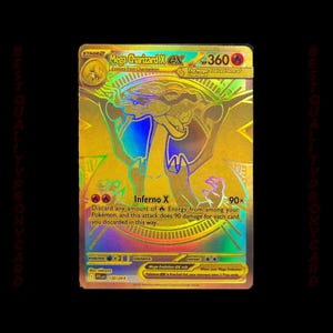 May include: A gold foil Mega Charizard X EX Pokémon card. The card features a detailed illustration of Charizard in a dynamic pose, with the text "Inferno X" and attack details. The card is a Stage 2 evolution.