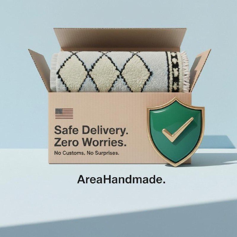 May include: A rolled-up, cream-colored rug with a diamond pattern is inside a cardboard box. The box has the text "Safe Delivery. Zero Worries. No Customs, No Surprises." and an American flag. A green shield with a gold checkmark is on the right.