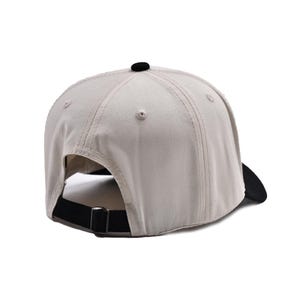 May include: A beige baseball cap with a black brim and adjustable strap. The cap features a black button on top and a curved brim. The back strap is black with a metal buckle.