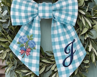 モノグラム入りの青いギンガムチェックのリースサッシュ、アジサイと愛国的な国旗の刺繍入り