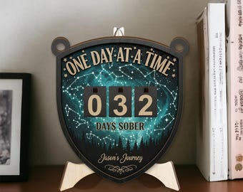 May include: A wooden desk calendar with the text "ONE DAY AT A TIME" and "DAYS SOBER". The calendar displays "032" days sober. The background features a starry night sky and a forest silhouette. The calendar is personalized with the name "Jason's Journey".