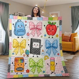 May include: A quilted throw blanket featuring a grid pattern of colorful school-themed illustrations including a blue backpack, a black composition notebook, a yellow pencil, a box of crayons, and various bows in pink, yellow, blue, and green.