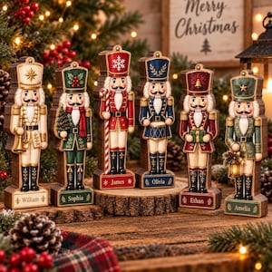 Peut inclure: Six figurines de casse-noisettes en bois alignées, chacune arborant des uniformes et accessoires uniques. Les socles sont personnalisés avec les prénoms William, Sophia, James, Olivia, Ethan et Amelia. Chaque figurine présente des détails peints.