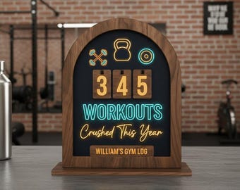 Puede incluir: Registro de gimnasio de madera con un fondo oscuro y texto de neón que dice "345 Entrenamientos Aplastados Este Año". El registro presenta iconos de pesas y una pesa rusa. La parte inferior del registro dice "William's Gym Log".