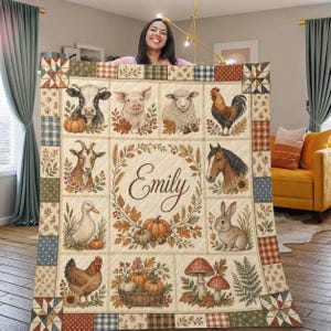 May include: A rectangular quilt featuring a grid of farm animals including a cow, pig, sheep, cockerel, goat, horse, duck, rabbit, and hen. The centre displays the name Emily surrounded by a wreath of autumn leaves, pumpkins, and mushrooms.