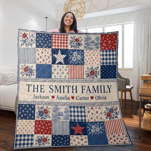 Può includere: Una trapunta patchwork rettangolare con uno schema di colori rosso, bianco e blu con motivi floreali, a quadretti e a righe. Il centro mostra il testo THE SMITH FAMILY sopra i nomi Jackson, Amelia, Carter e Olivia con cuori rossi.
