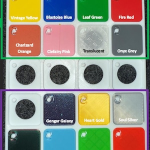 May include: A grid of colorful acrylic squares, each with a small hole and labeled with a unique color name. Colors include Vintage Yellow, Blastoise Blue, Leaf Green, Fire Red, Charizard Orange, Clefairy Pink, Translucent, Onyx Grey, Gengar Galaxy, Heart Gold, Soul Silver, Iridescent, Blue Glow, Green Glow, and Red Glow.