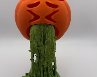 Puede incluir: Una calabaza impresa en 3D con una sustancia verde, frondosa y similar a una vid que sale de su boca. La calabaza tiene una cara enojada tallada.