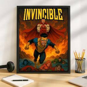 Op de afbeelding: Een ingelijste poster met het woord "INVINCIBLE" in grote gele letters. De poster toont een stripboekachtige illustratie van een superheld in een blauw en geel kostuum dat door de lucht vliegt. De superheld wordt omringd door vlammen en andere personages.
