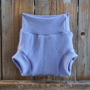 Puede incluir: Un par de bombachos para bebé de color lavanda hechos de tela suave y elástica. Los bombachos tienen una cintura elástica ancha y un ajuste holgado.