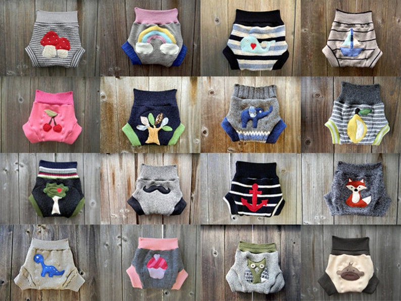 Może przedstawiać: Kolekcja 16 kolorowych, wzorzystych i ozdobionych aplikacjami pieluch materiałowych. Każda pielucha ma inny wz&oacute;r, w tym grzyb, tęczę, wieloryba, żagl&oacute;wkę, wiśnię, drzewo, słonia, cytrynę, lisa, kotwicę, dinozaura, babeczkę, sowę i małpę.