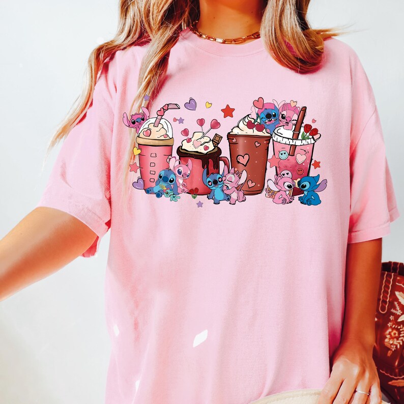 Puede incluir: Camiseta rosa claro con un dise&ntilde;o de personajes de dibujos animados y bebidas de caf&eacute;. El dise&ntilde;o incluye corazones, estrellas y personajes en azul, rosa y marr&oacute;n. La camiseta tiene cuello redondo y mangas cortas.