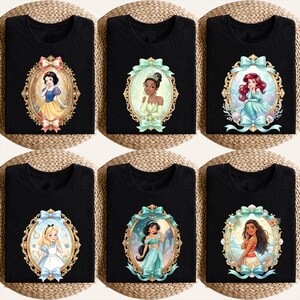 Op de afbeelding: Zes zwarte t-shirts met verschillende Disney-prinsessen in sierlijke ovale frames. De prinsessen zijn Sneeuwwitje, Tiana, Ariel, Alice, Jasmine en Moana. Elk frame heeft een uniek kleurenschema, met strikken en decoratieve elementen.