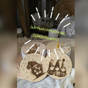 Könnte beinhalten: Weihnachtsschmuck aus Holz und runde Schachteln mit Zwergenillustrationen. Die Ornamente und Schachteln haben eine helle Holzoberfläche mit geätzten Designs. Der Text "WEIHNACHTS EDITION WUNSCHMOTIV" ist in Neongrün geschrieben.