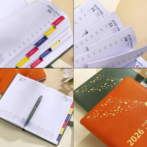 May include: A collection of open 2026 daily planners with colorful month tabs. The planners have a leather-like cover in orange and green. One planner is open to a page with a pen.